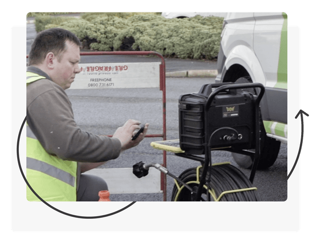 Technician surveying a drain contained in a decorative frame