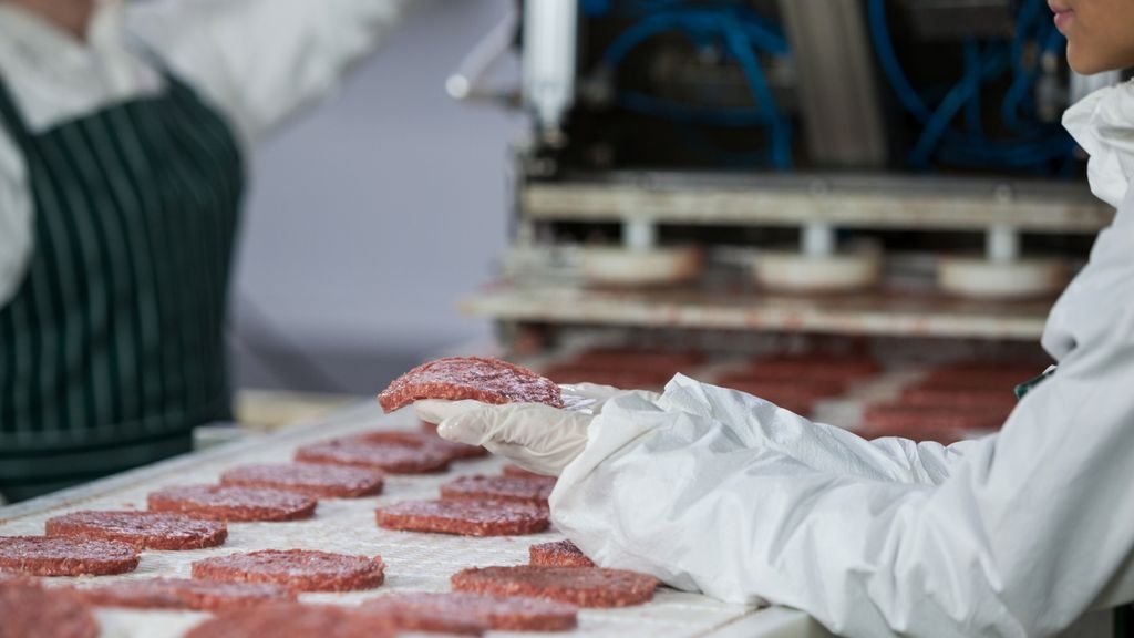 butcher processing hamburger patty