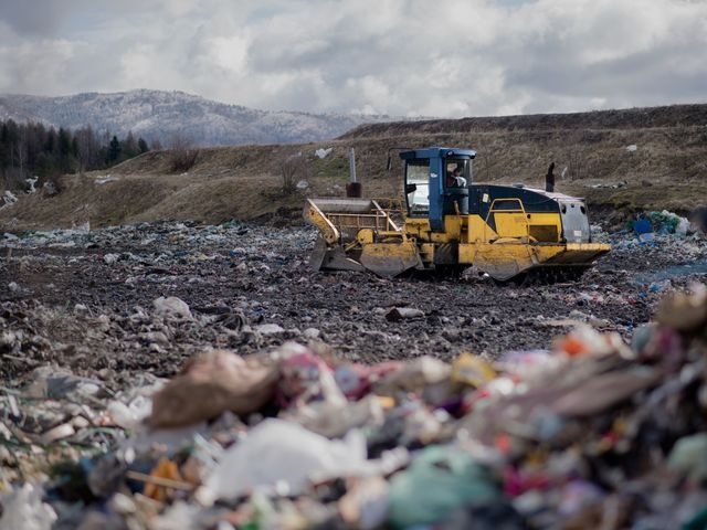 A bulldozer working on a waste site