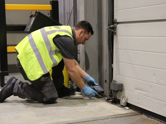 Contego technician placing a rat box in a customer warehouse.